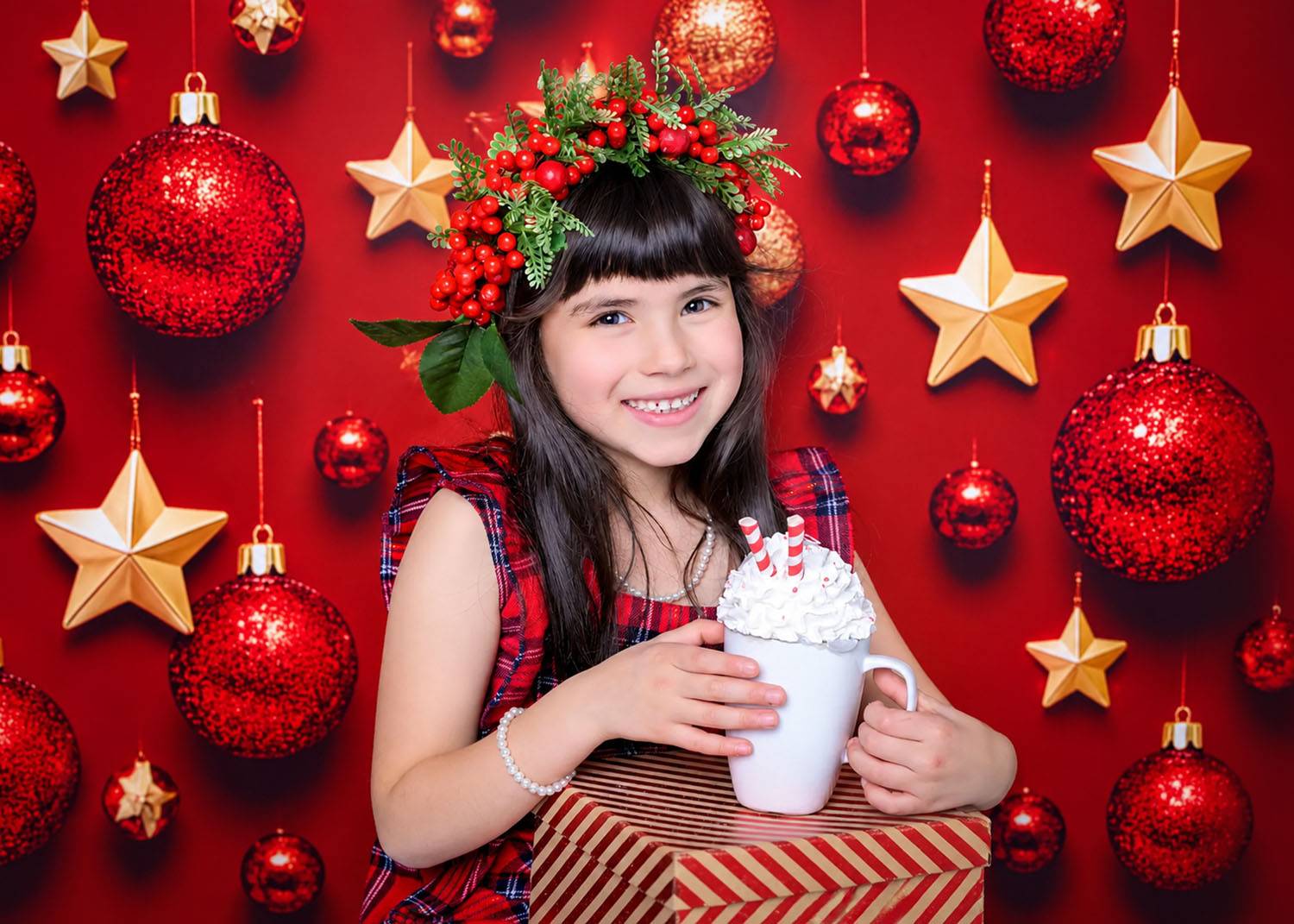 Little girl holding hot chocolate in a festive Christmas photoshoot with red baubles and gold stars in Glasgow